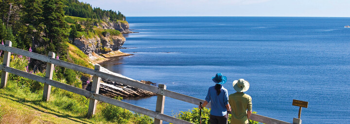 Zwei Wanderer genießen Ausblick über die Küste von Québec